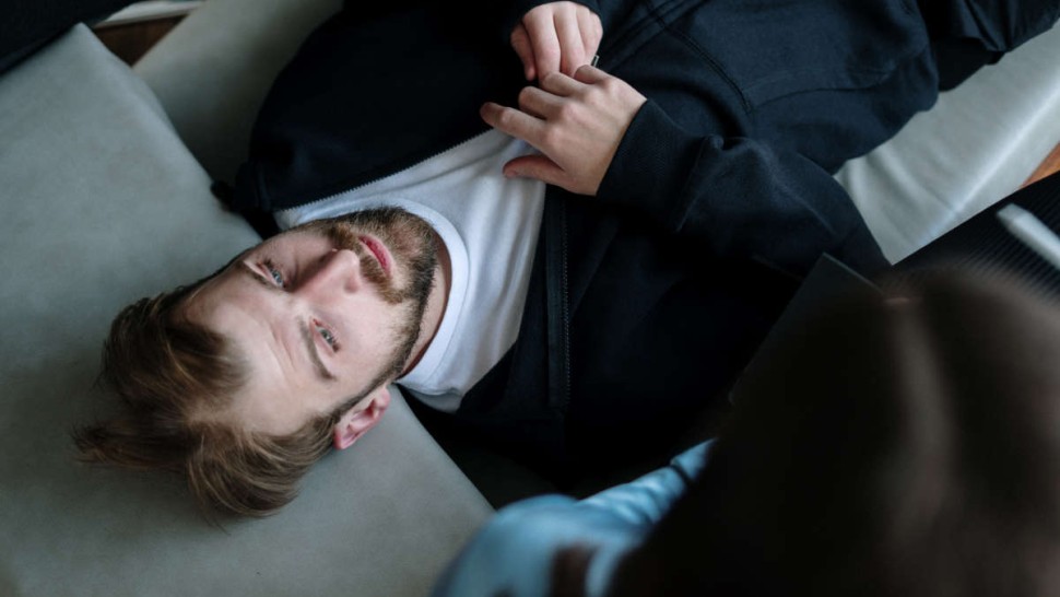 Patient lying on a sofa in a hypnosis session