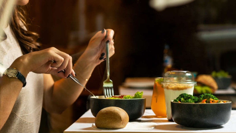 Concentrated young woman eating her dinner