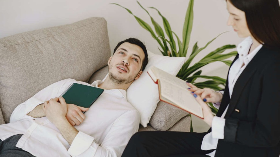 Patient allongé sur un sofa en séance d'hypnose