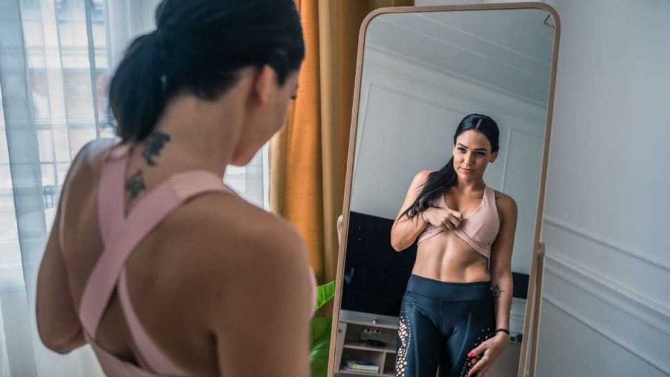 Young woman looking at herself in a mirror