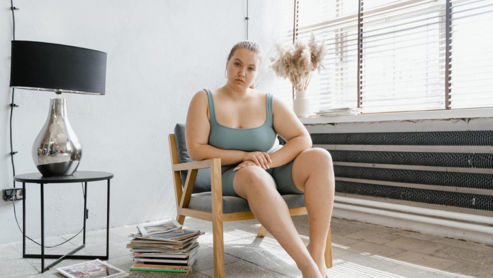 A sad obese woman sitting on a chair