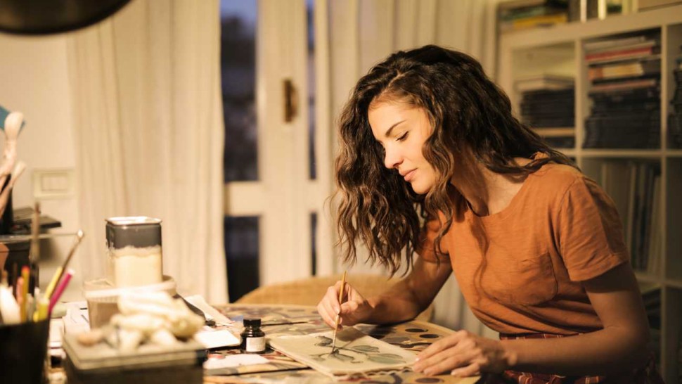 Jeune femme concentrée sur une peinture