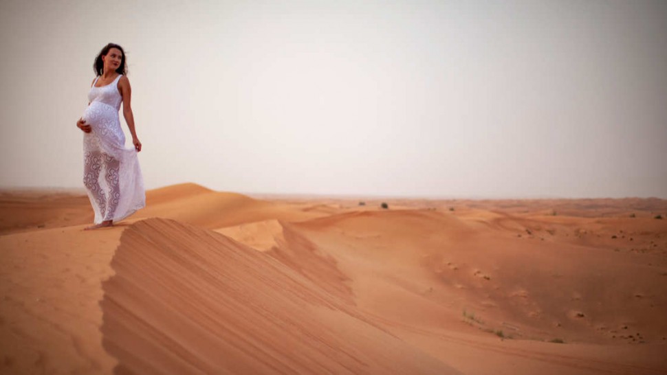 Photo d'une femme enceinte dans un désert