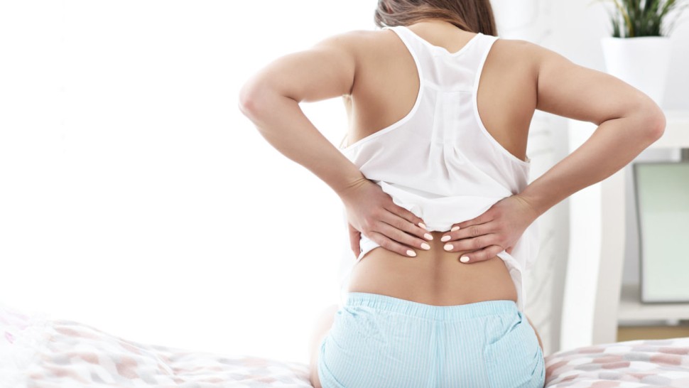 Jeune femme assise souffrant d'un lumbago