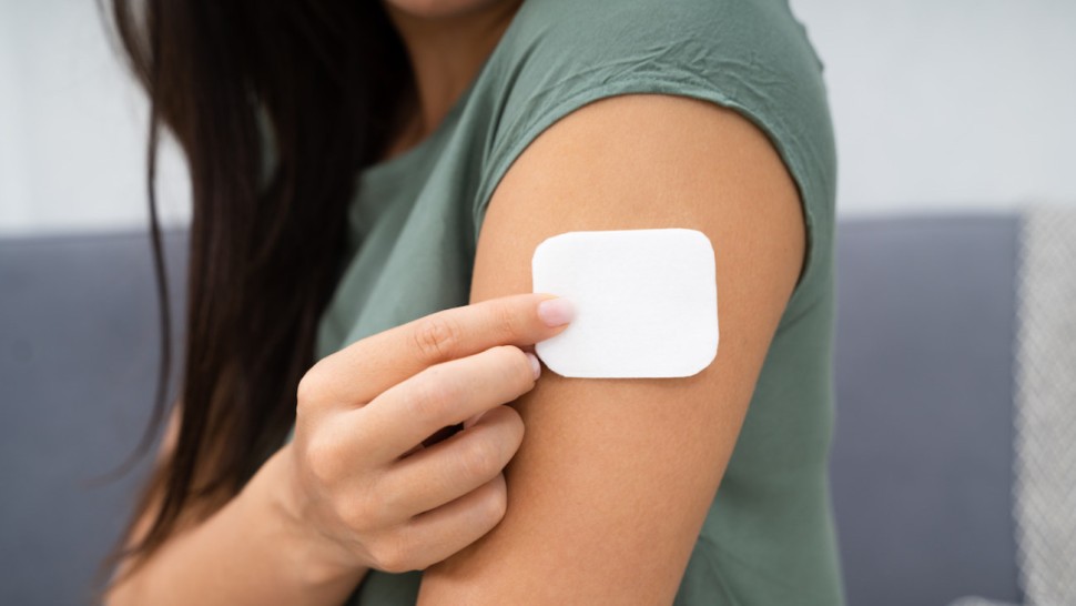 Une femme qui applique un patch nicotinique 