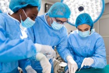 Équipe de chirurgiens en uniforme effectue une opération sur un patient dans une clinique