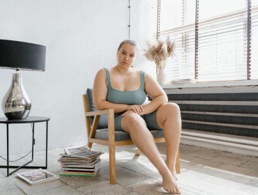 A sad obese woman sitting on a chair