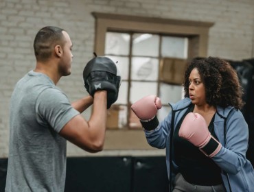 Obese woman in boxing session with her trainer