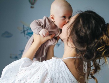 Une jeune maman qui porte son bébé