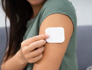 Une femme qui applique un patch nicotinique 