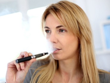 Jeune femme qui vapote une e-cigarette