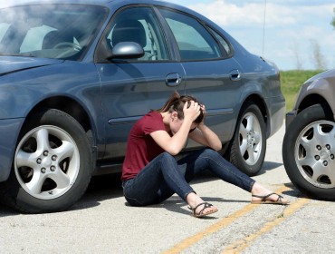 jeune assise sur la route après un accident