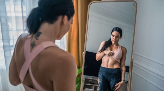 Young woman looking at herself in a mirror